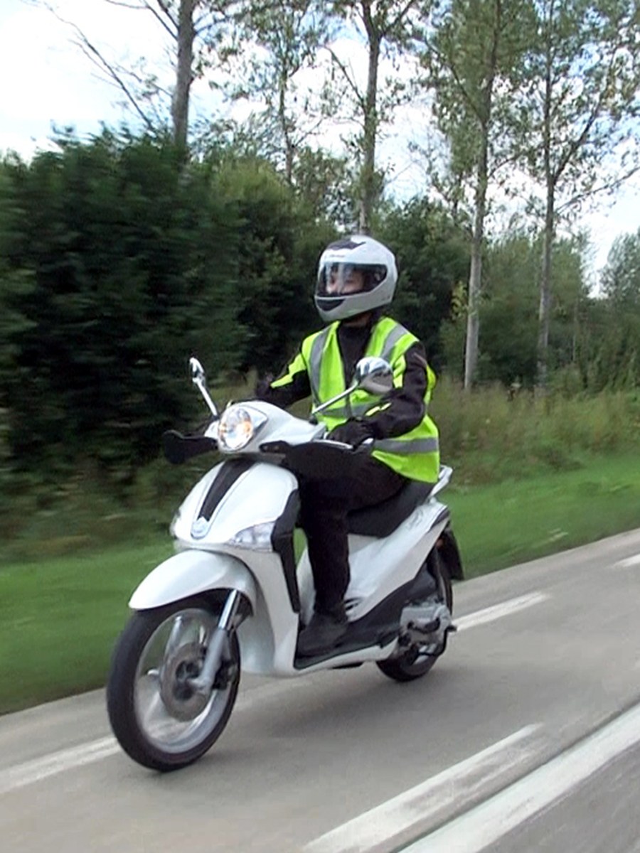 Bromfietsles van Rijschool Rijswijk, rijder met veiligheidshesje